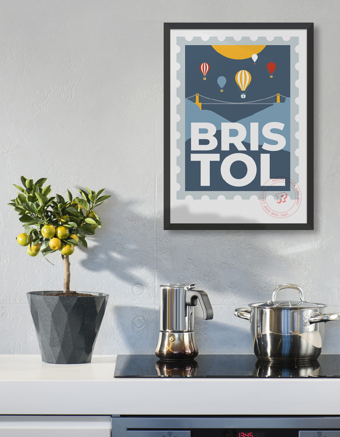 Lifestyle image depicts the customisable Bristol stamp print featuring the suspension bridge and hot air balloons against a grey & yellow background